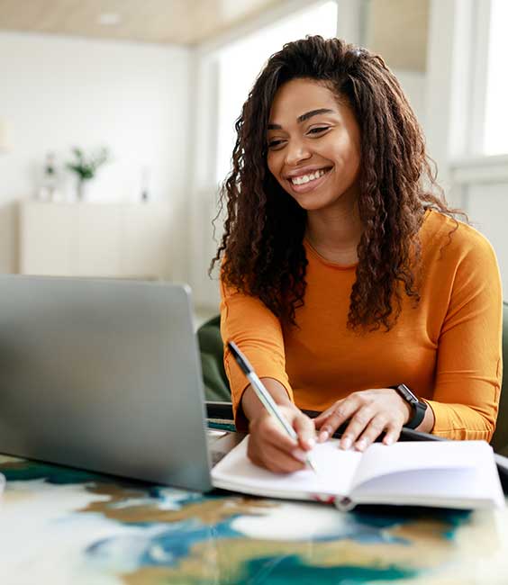 Woman Writing Notebook At Laptop